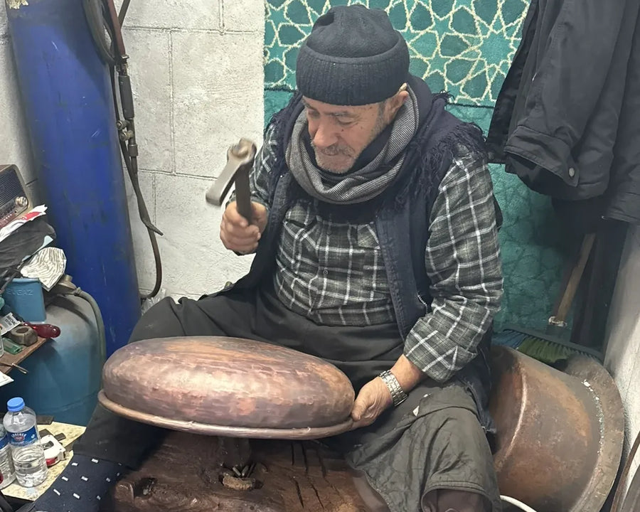 Mikdat Çelik treibt ein Kupferwaschbecken mit dem Hammer in seiner Werkstatt in Gaziantep